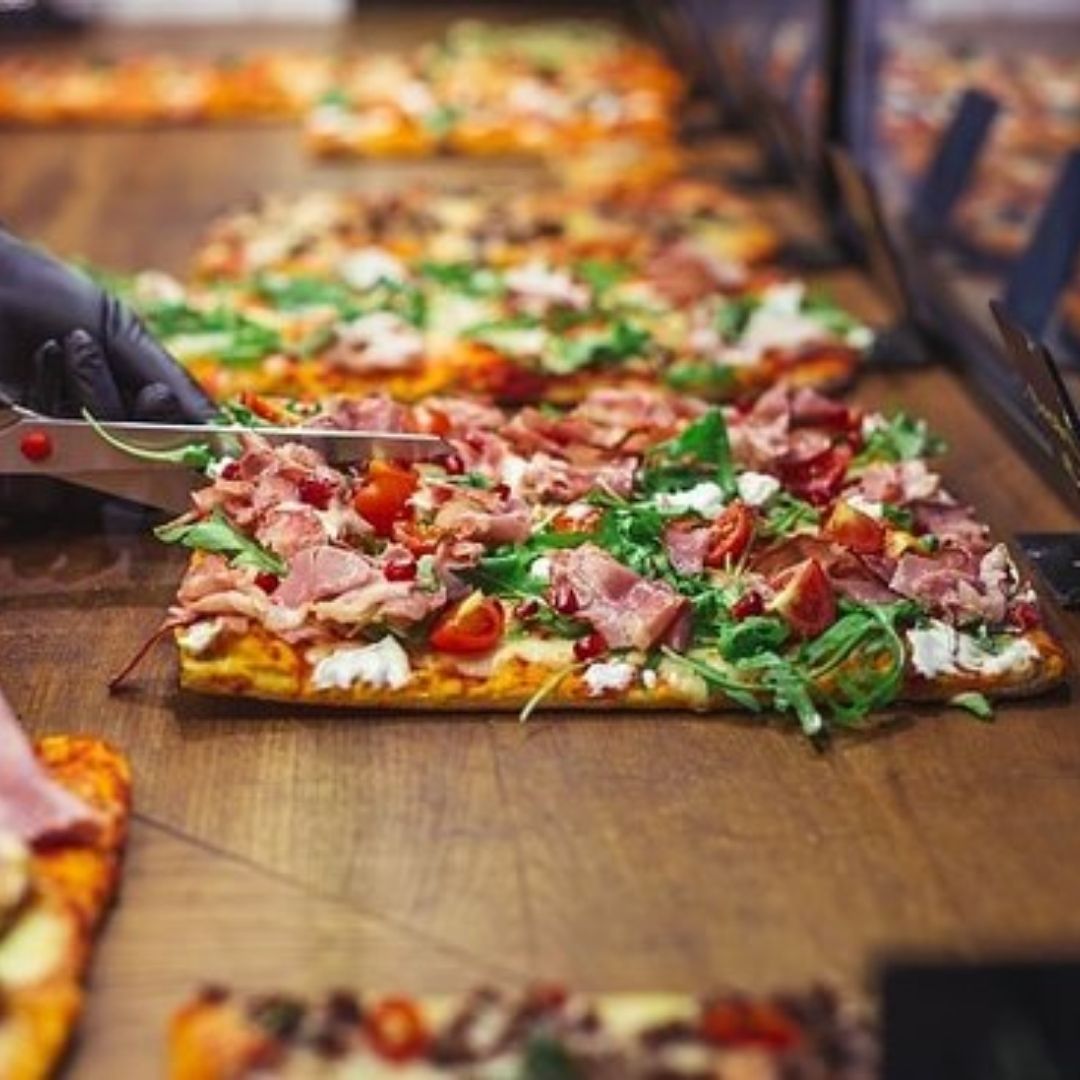 A chef adding toppings to an authentic italian pinsa pizza